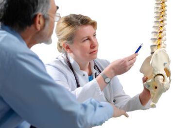 Lekarz konsultuje z pacjentem objawy osteochondrozy odcinka piersiowego kręgosłupa